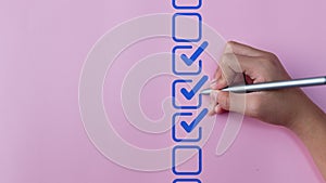 Checklist concept, Hand holding stylus pen checking mark on checkboxes photo
