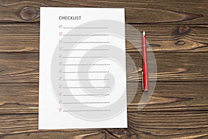Checklist on a sheet of paper, fountain pen on the background of a wooden table