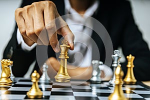 Checkmate. businessman hand moving golden chess figure on chess board game competition