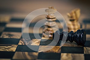 Checkmate on wooden chess board fallen king