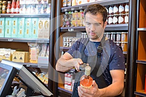 Checkout clerk scanning bottle wine