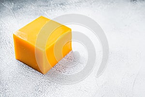 Cheddar Cheese block on a kitchen table. White background. Top view. Copy space