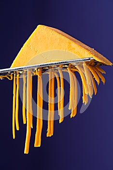 Cheddar Cheese on Grater. Closeup Studio Image