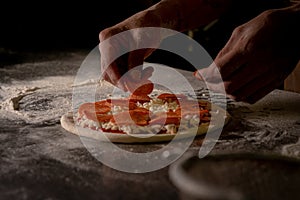 Cheef preparing a peperonni pizza in a kitchen