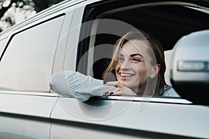 Cheeful caucasian woman with braces system enjoying road trip and looking out from car window