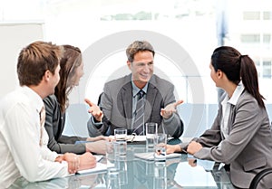 Cheeful manager talking to his team at a meeting