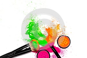 Cheek brush with neon cosmetic powder colorful pile on white background