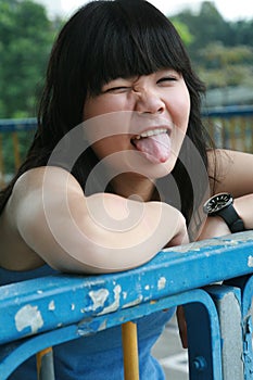 Cheeky Asian girl sticking her tongue out