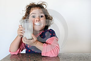 Cheeky young girl drinks milk