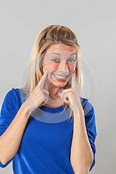 Cheeky young woman with fake smile expressing optimism