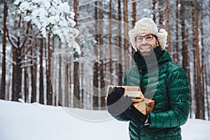 Cheerfu pleasant looking beard male model holds firewood, spends free time in forest, going to fry shish kebab, has picnic in fami