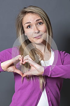 Cheerful 20s woman showing heart shape with hands