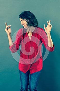 Cheerful 30s woman dancing with dynamic hand gesture