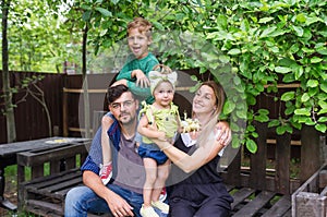 Cheerful active family of four having fun at countryside in summer day.