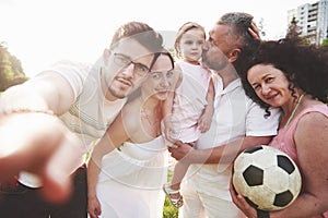 Cheerful active family having fun at countryside in summer day.