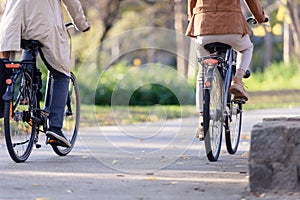 Cheerful active senior couple riding bicycles in public park together having fun. Perfect activities for elderly people.