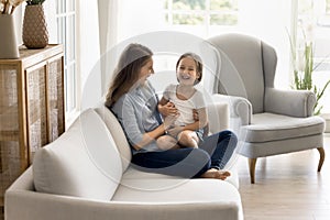 Cheerful adorable little girl enjoy playtime with happy mum