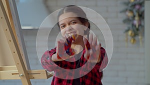 Cheerful adorable teenage girl with painted hands making animal claws gesture
