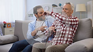 Cheerful adult males sharing memories father and son joking and having good time