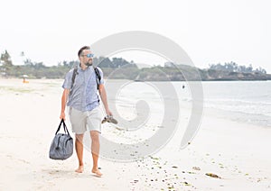 Contento un adulto uomo borsa divertirsi sul tropicale Spiaggia 