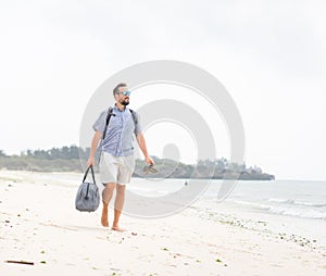 Contento un adulto uomo borsa divertirsi sul tropicale Spiaggia 