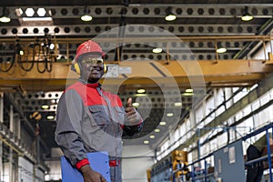 Cheerful African American Blue-Collar Worker Giving Thumbs Up In A Factory