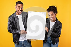 Cheerful African American Couple Showing Blank Poster Over Yellow Background