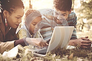 African American family lying down in park and using la photo