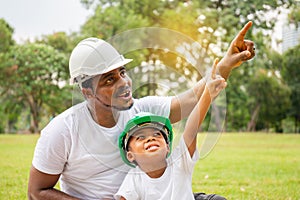 Cheerful african american father and son in hard hat having a picnic in the park, Happiness family concepts