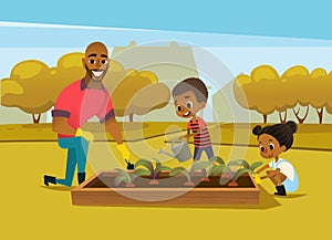 Cheerful African American father and two kids dressed in rubber boots cultivate vegetables growing in bed against trees