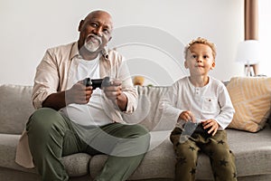 Cheerful African American Grandpa And Grandson Playing Videogame At Home