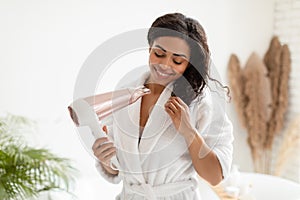 Cheerful African American Lady Drying Hair Using Blowdryer In Bathroom