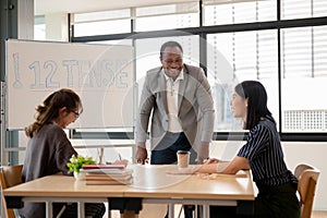 A cheerful African American male English teacher enjoying conversation with Asian students