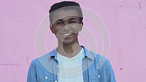 Cheerful African-American male teenager smiling at camera, positive mood