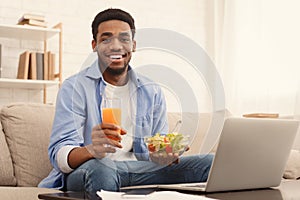 Cheerful african-american man eating healthy lunch at home