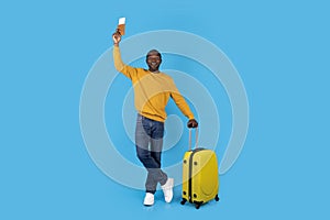 Cheerful african american mature man tourist travelling alone, blue background