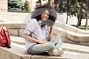 Cheerful African American Student Girl Using Laptop Sitting Outdoors