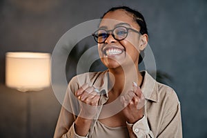 Cheerful african american woman holding clinched fists and smiling photo