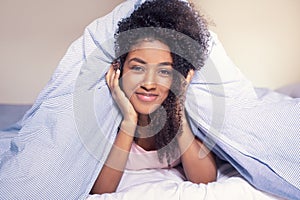 Cheerful african american woman portrait in bed