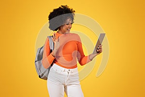 Cheerful African American woman waving during a video call on a tablet
