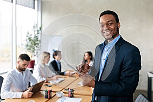 Cheerful African Businessman Using Tablet Computer Standing In Modern Office