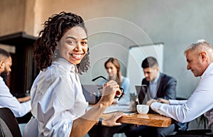 Cheerful African Businesswoman Sitting With Business Partners In Modern Office