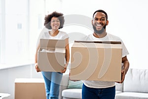 Cheerful African Couple Carrying Moving Boxes Into New Appartment