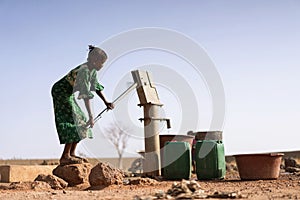 Cheerful African ethnic Girl Bringing Crisp Water in a village