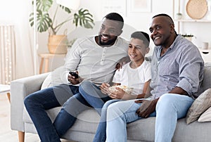 Cheerful african grandpa, father and son relaxing together in living room