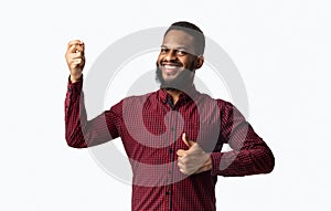 Cheerful African Guy Gesturing Thumbs-Up Approving Taste Over White Background