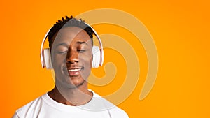 Cheerful african guy in headphones relaxing and smiling