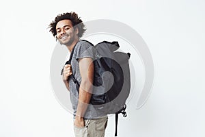 Cheerful african man with backpack smiling looking at camera. White background.