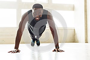 Cheerful african sportsman performing power load exercises
