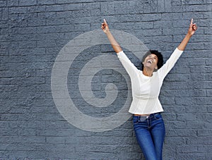 Cheerful african woman with hands raised pointing up